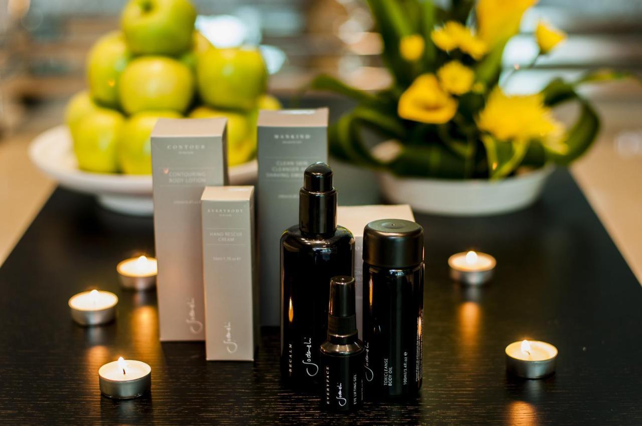 Dubai International Terminal Hotel Exterior foto The photo features several skincare or beauty product bottles arranged on a dark tabletop. There are three black bottles of varying sizes, likely containing serums or oils, alongside several light-colored boxes with a minimalist design, possibly for 